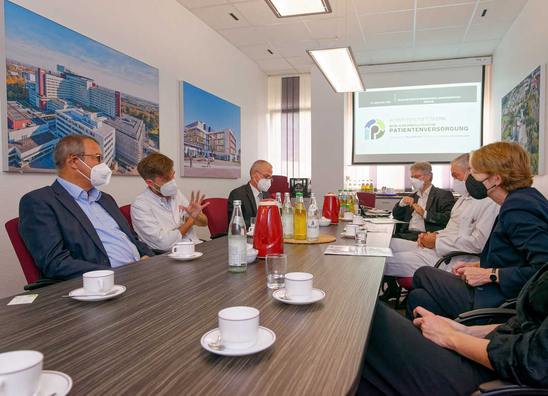 Beteiligte der Uniklinikum Augsburg sitzen gemeinsam an einem Tisch